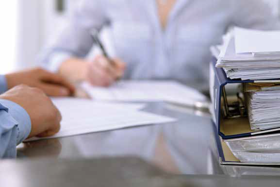 two people at a table with paper between them