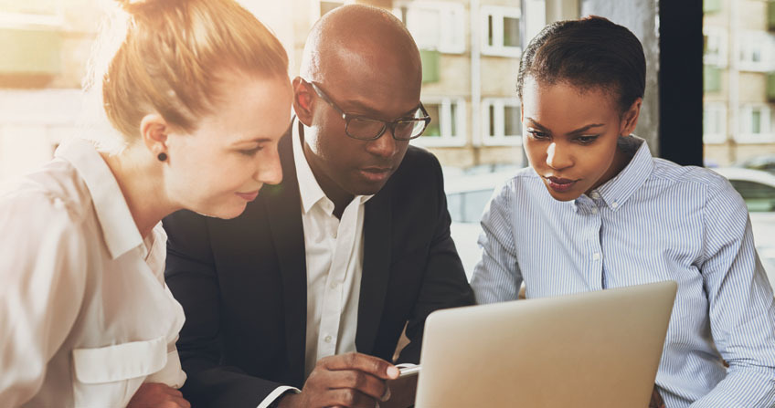 Business people looking at a laptop