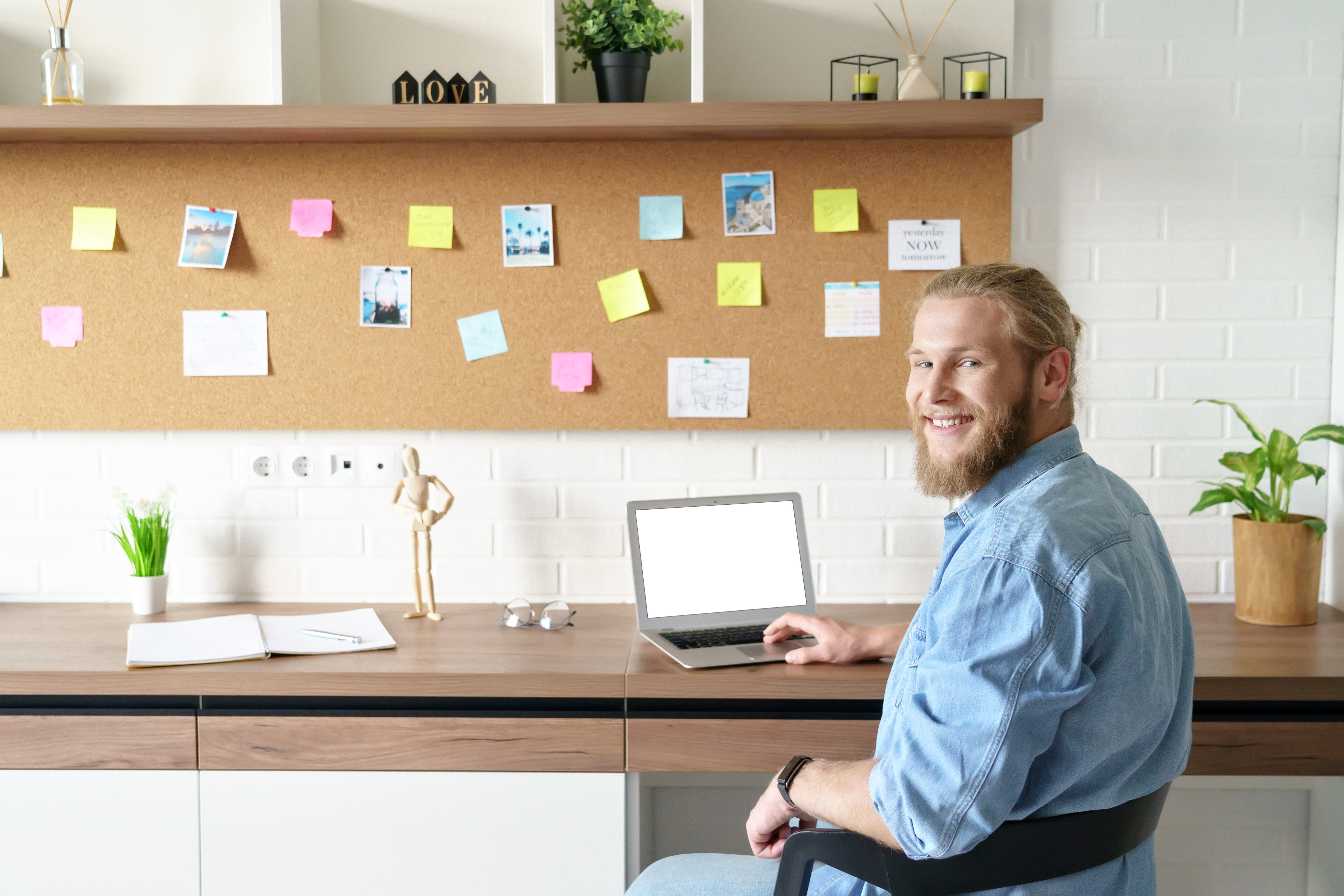 Remote worker sitting and smiling at his desk.