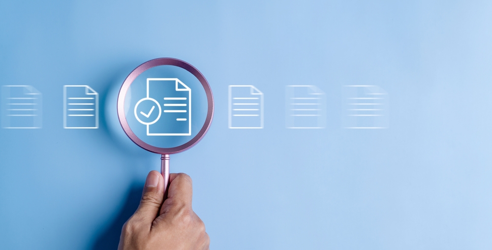 hand holding magnifier to document