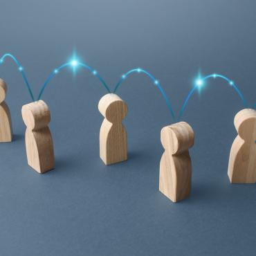 wooden figures == illustration or photo -- with lights jumping from figure to figure and start above each as though sharing information and helping