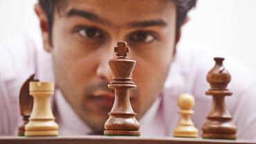 man staring at chess pieces
