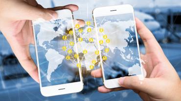 two hands hold phones next to each other to connect with a transparent map overlaid atop of them to show connectivity