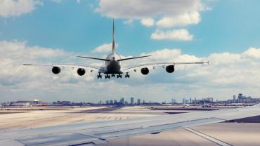 a plane about to land with the city in the distance