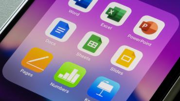 Screen of iPhone with Office Suite apps and purple background.
