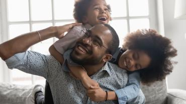 Two children hugging their father