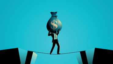 Businessman walking tightrope with money