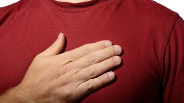 person, white skin, just showing chest with hand over it like pledging