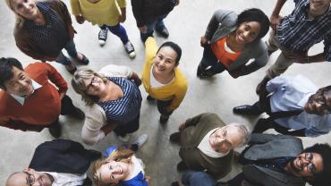 a group of diverse people standing together and looking up