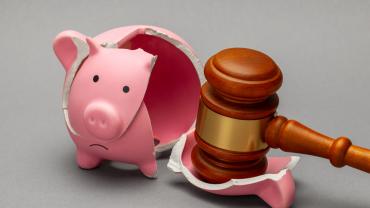 piggy bank broken with gavel on one piece