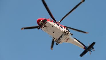 helicopter in sky that says "rescue" on the underside