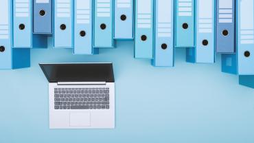 Computer under a long row of binders. 