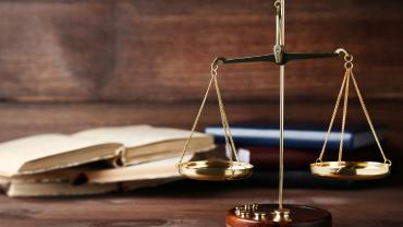 Law scale on a table in front of a pile of books. 