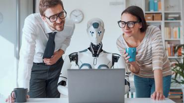 Workers supervise a robot