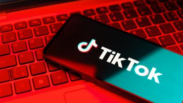 Image of TikTok on a phone with red background