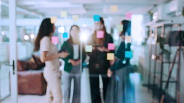 Group of workers at a window with sticky notes