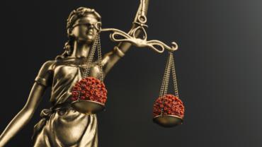 a statue of blind lady justice with covid-19 virus cells balanced on the scales