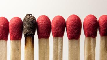 a row of matches. one is burnt out