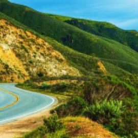 two lane road winding around hilly countryside 