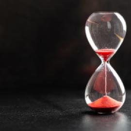 hourglass with sand running through and much already on bottom