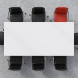 table with chairs around it and no one there, one red chair, the rest black -- symbolizing here the person who chose to cancel the meeting
