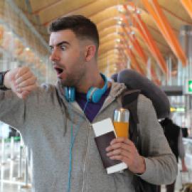 man, white, it appears, in airport looking at watch, panicked