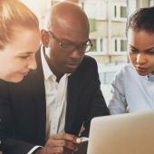 Business people looking at a laptop