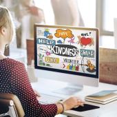 A woman looking at her computer which is full of positive messages: Hope, Help, Kindness, Share, Volunteer, Thank You.
