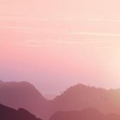 Person with both hands in the air at the top of a mountain