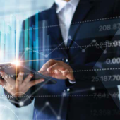 several graphs overlaying an image of a person in a suit holding a tablet