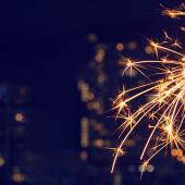 Sparkler lit against a cityscape background