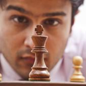 man staring at chess pieces