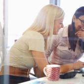 two professional woman seated together at a desk collaborating 