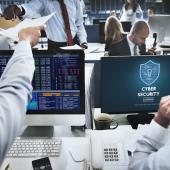 employees working on computers with "cyber security" written on the screen
