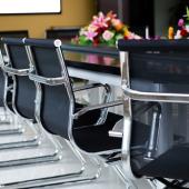 business chairs placed around a table with flowers on top