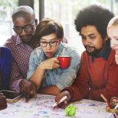 seven diverse professionals gathered around a table during a strategy meeting