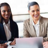 diverse professionals seated around a computer