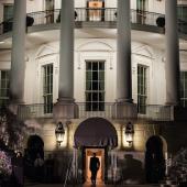 White House lit at night and man walking into the southside entryway