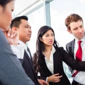 Four professionals standing around discussing a chart