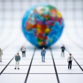 Globe with miniature lawyers standing in front