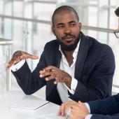 Millennial employees gathered in boardroom for training, black boss leading corporate team during seminar learning at modern office