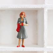 Doll figurine alone on a shelf