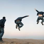 looks like man about to jump outside, horizon in back, jumps, jumps higher with arms up