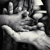 black-and-white of hands holding each other, different skin shades