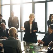 woman appearing to be leading group discussion, white, gray hair, diverse group