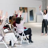 A group of participants raising their hands, being engaging in a training session. 