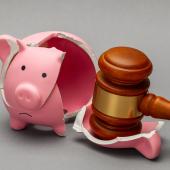 piggy bank broken with gavel on one piece
