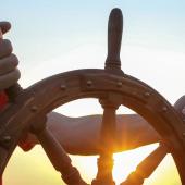 hands, looking white, steering ship's wheel