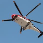 helicopter in sky that says "rescue" on the underside