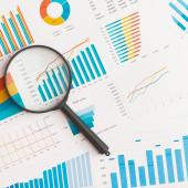 Magnifying glass over a stack of papers. 